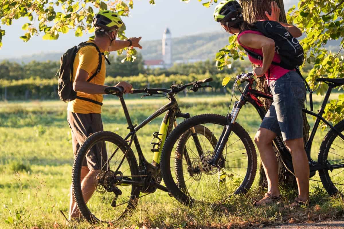 Cycling in Vipava Valley. Couple on electric mountain bikes exploring the green Slovenia. RockVelo rental bikes.