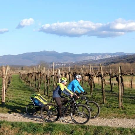 Couple cycling with ebikes and child bike trailer. Photo by RockVelo tours Slovenia