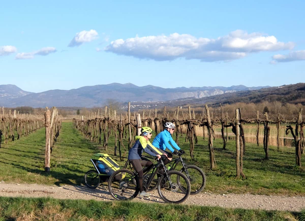 Couple cycling with ebikes and child bike trailer. Photo by RockVelo tours Slovenia